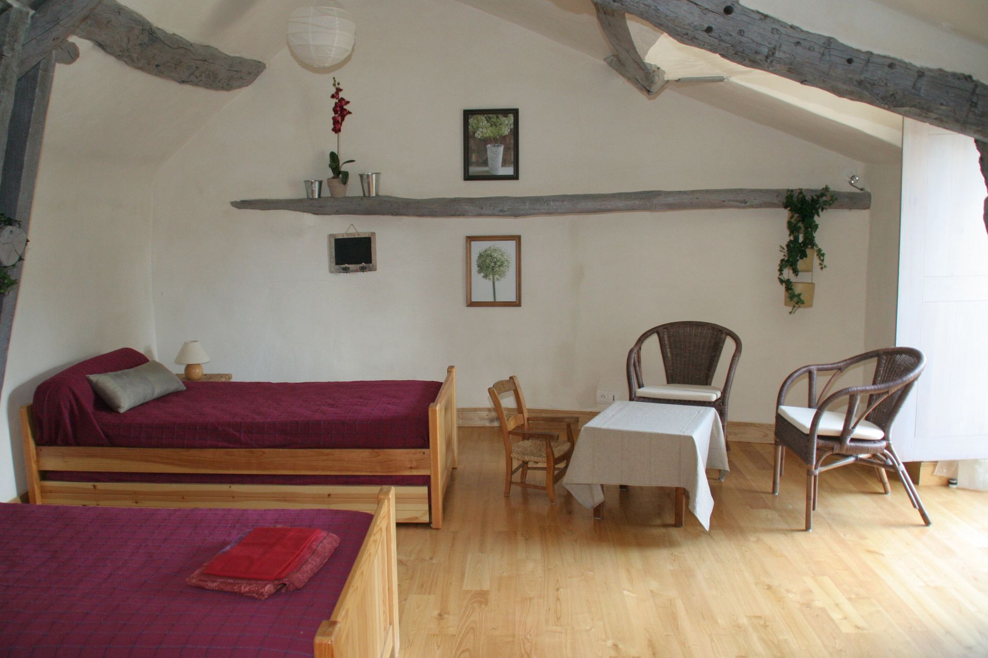 Deux lits simples avec parure de draps bordeaux