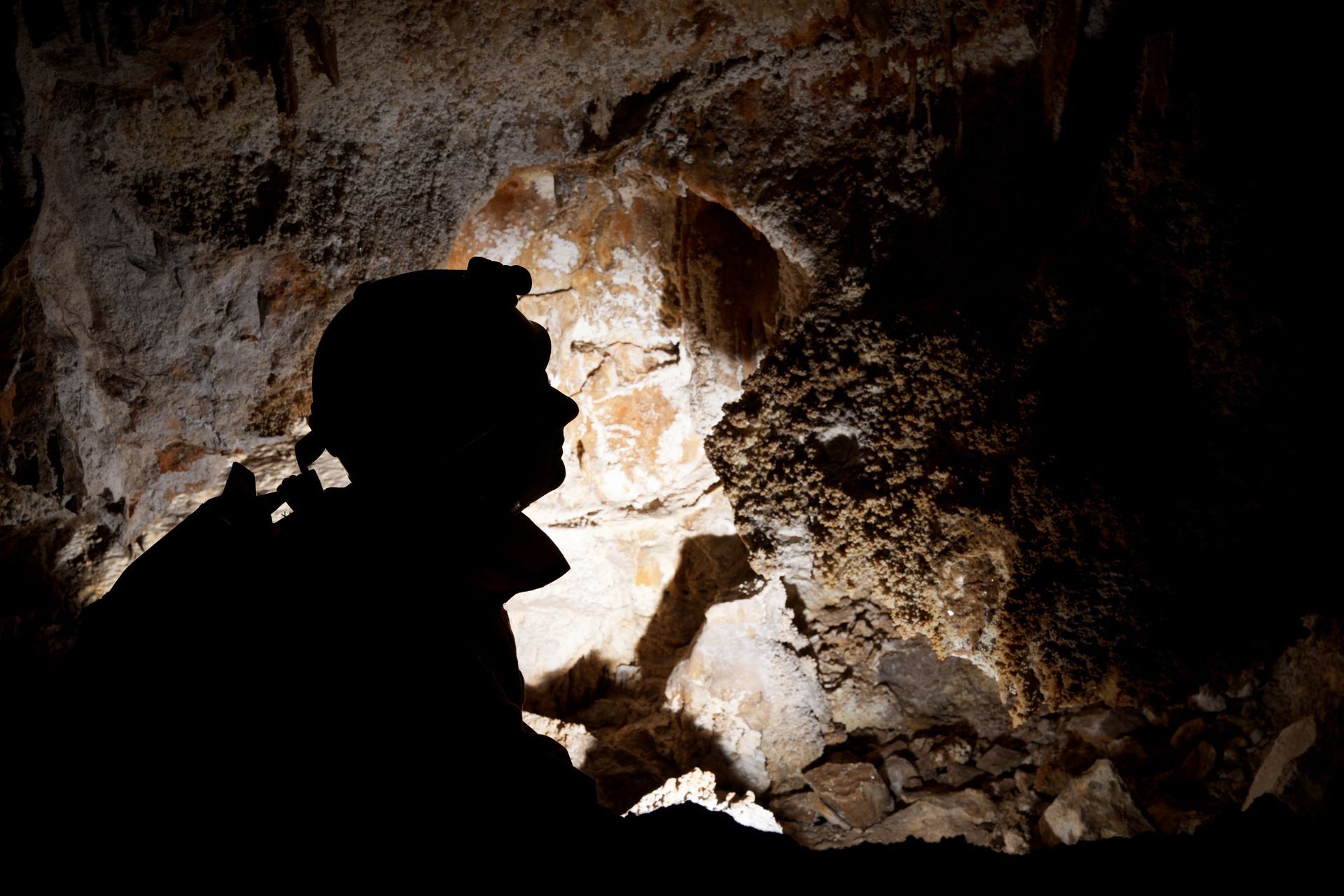 Silhouette d'une personne dans une grotte éclairée