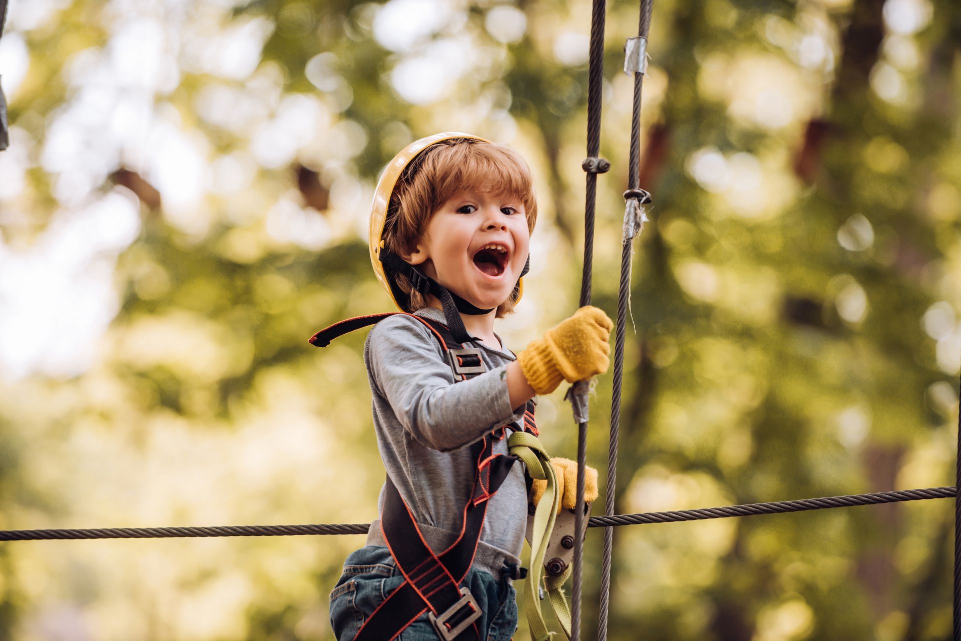 Enfant heureux équipé d'un casque, de gants et d'un baudrier