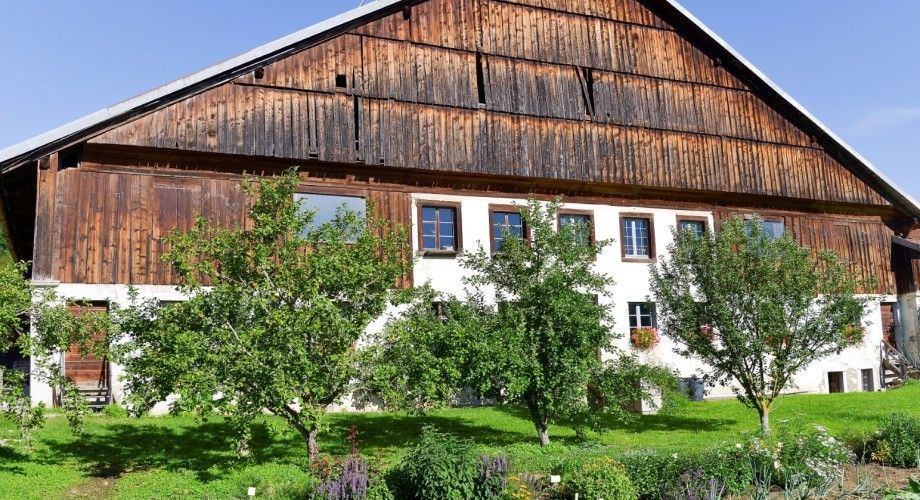 Grande maison blanche avec toit en bois