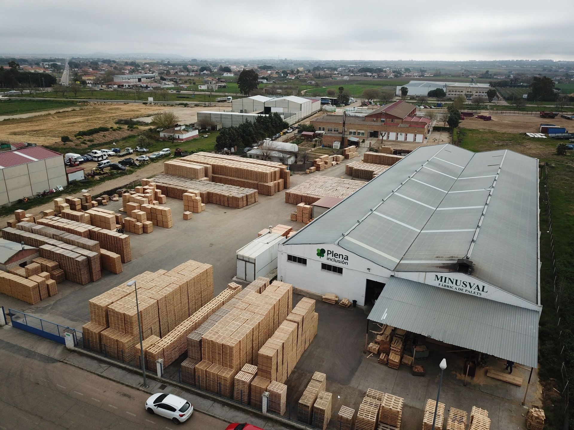 Una vista aérea de un gran almacén lleno de paletas de madera.