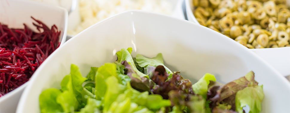 Eine Nahaufnahme eines Salats in einer Schüssel mit anderem Gemüse.