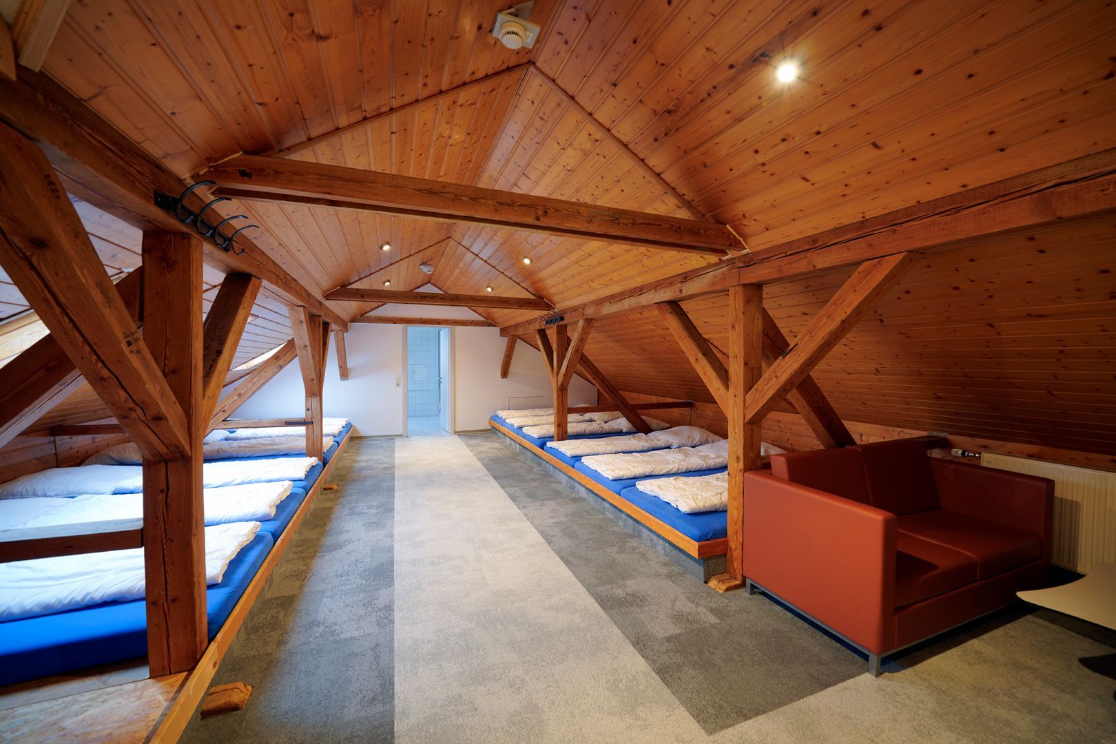 Ein Zimmer mit vielen Betten und einer Couch darin