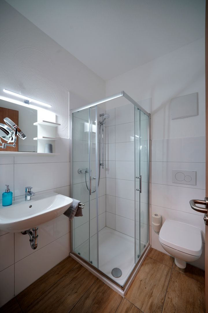 Ein Badezimmer mit Waschbecken, Toilette, Dusche und Spiegel.