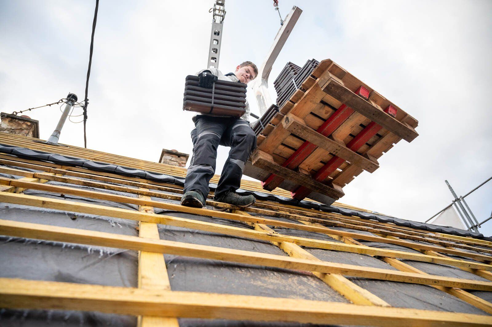 Membre de l'équipe de BS Toitures transportant des tuiles