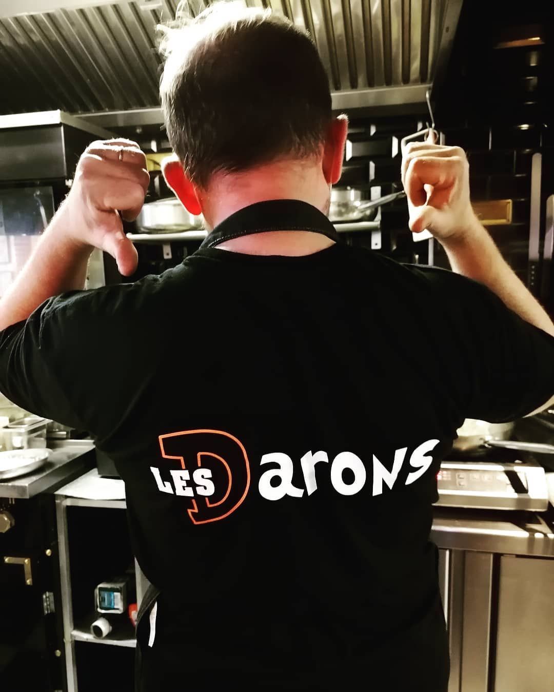 Personne en t-shirt noir dans une cuisine.