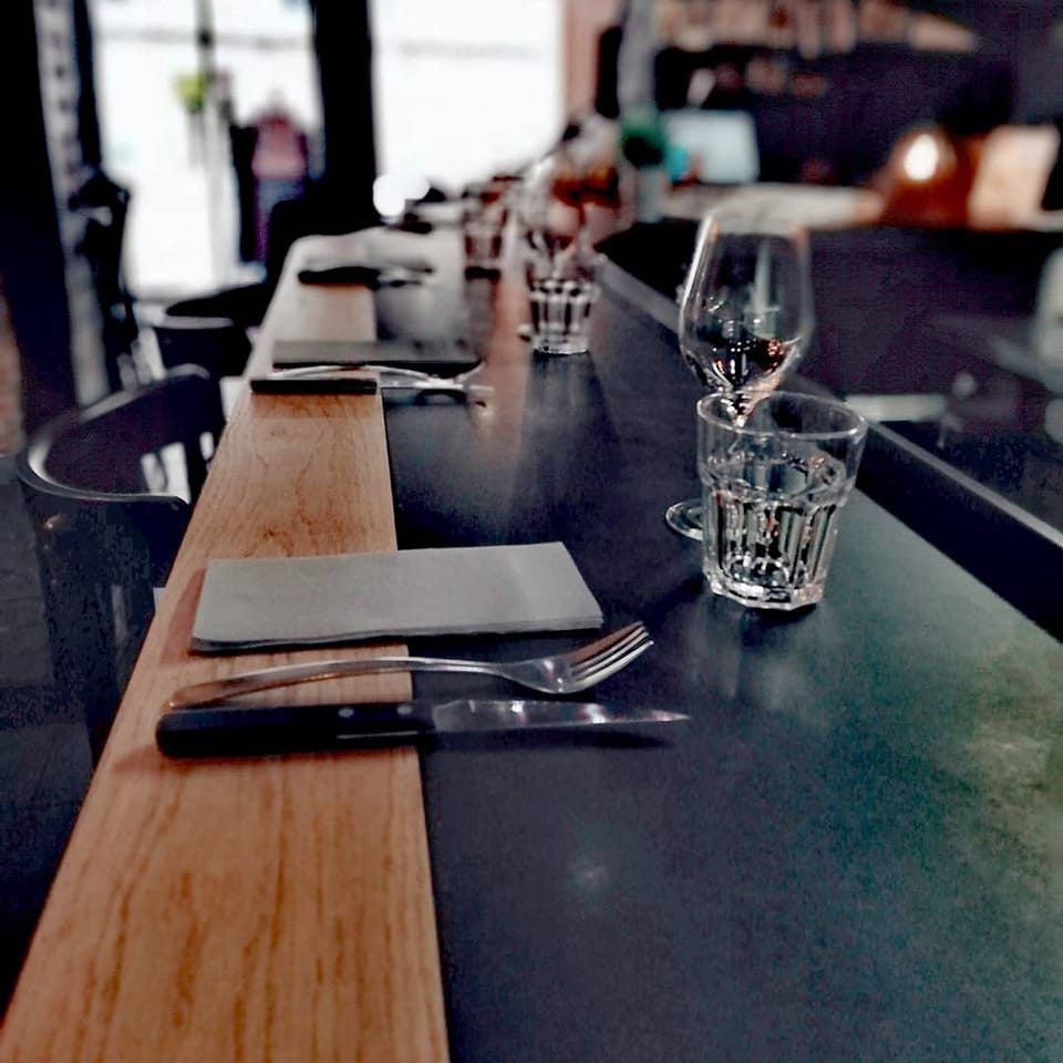 Dressage de table au restaurant avec couverts, verres et serviettes.