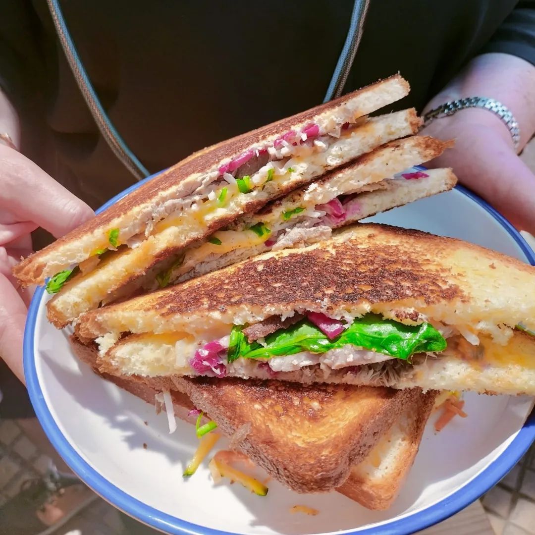 Sandwichs grillés garnis, présentés dans un bol à bordure bleue.
