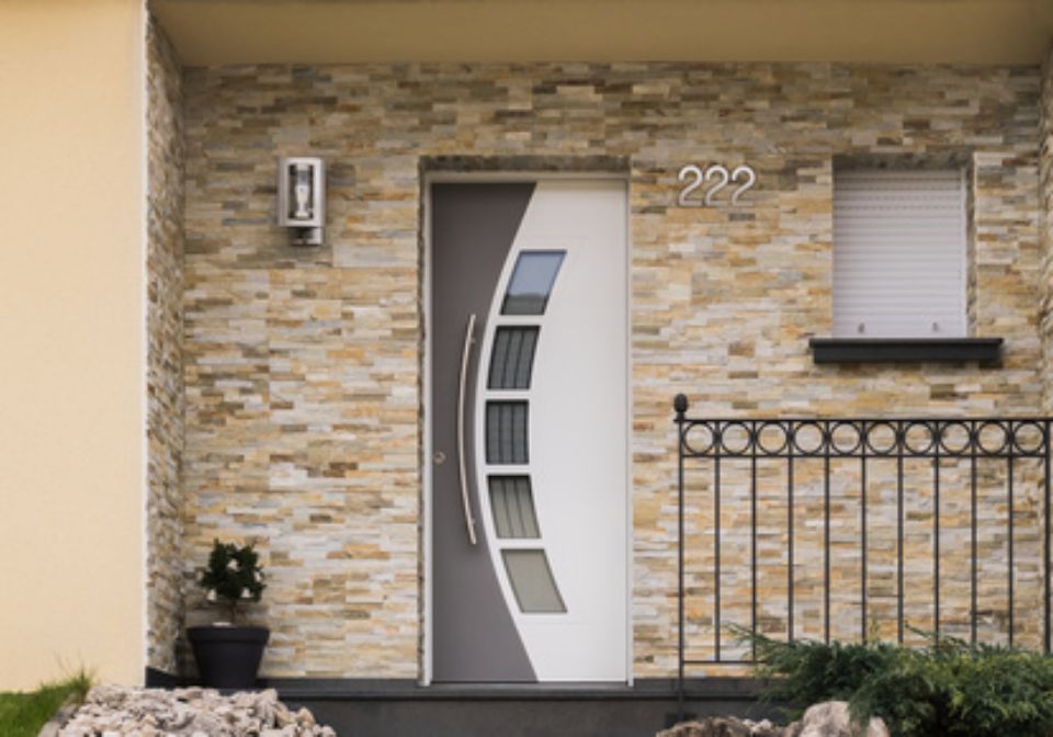 Moderner Hauseingang mit Steinfassade, grau-weißer Tür, Nummer 222.