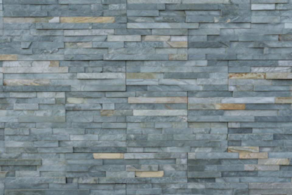Graue und beige gestapelte Steinmauerstruktur.
