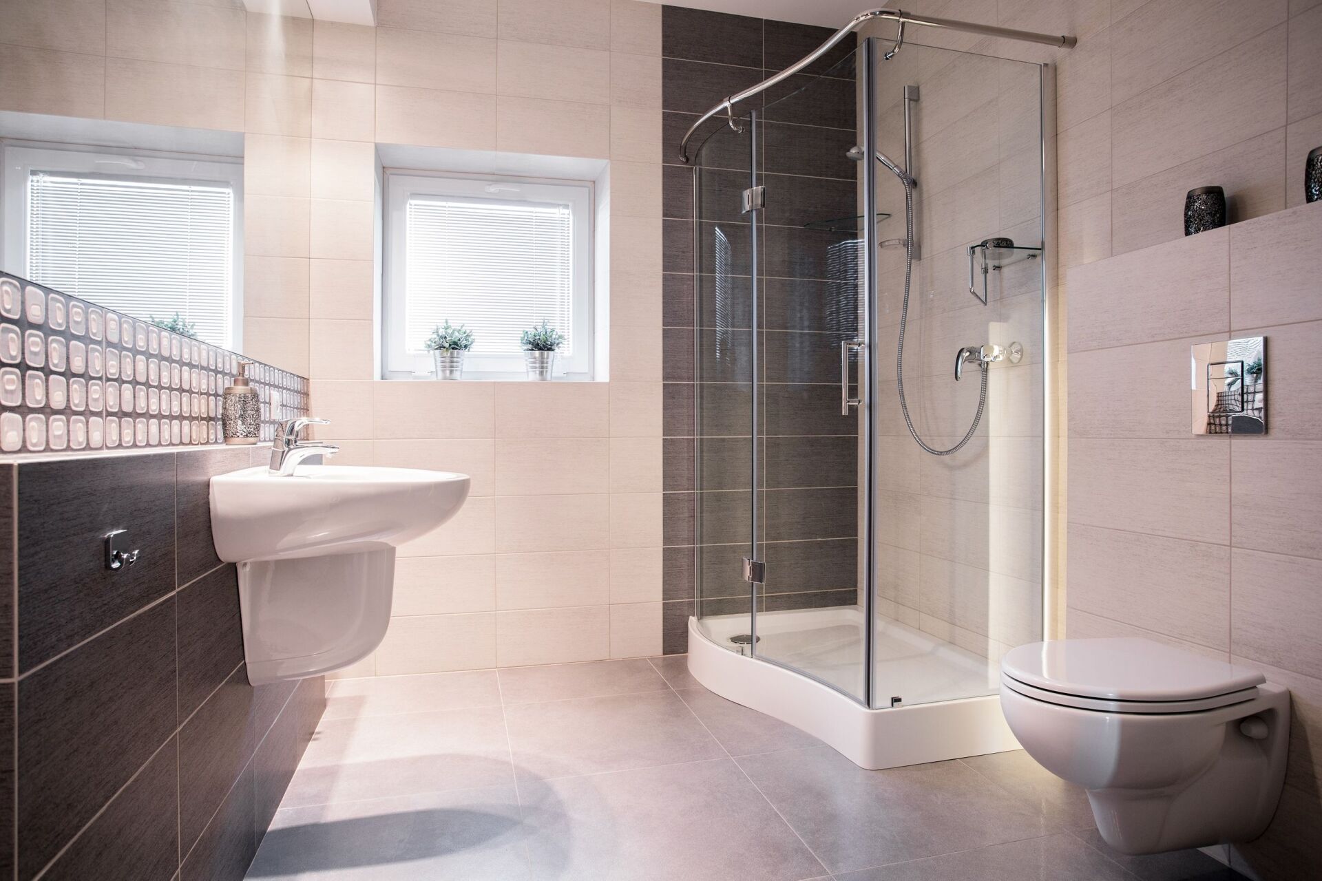 Modernes Badezimmer mit Glasdusche, Waschbecken und Toilette. Neutrale Farben.