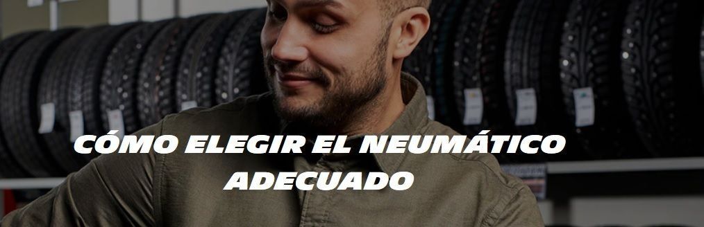 Un hombre está parado frente a una pila de neumáticos.