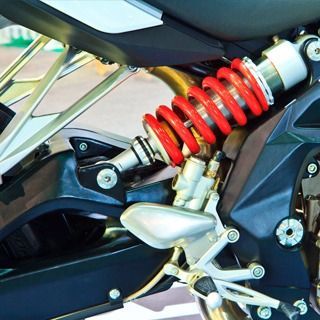 Un primer plano de una motocicleta con un amortiguador rojo.