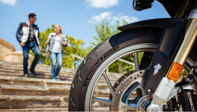 Un hombre y una mujer bajan las escaleras al lado de una motocicleta.