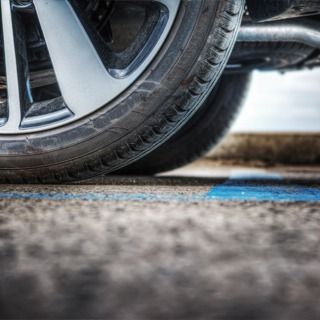 Un primer plano de un neumático de automóvil en un estacionamiento.