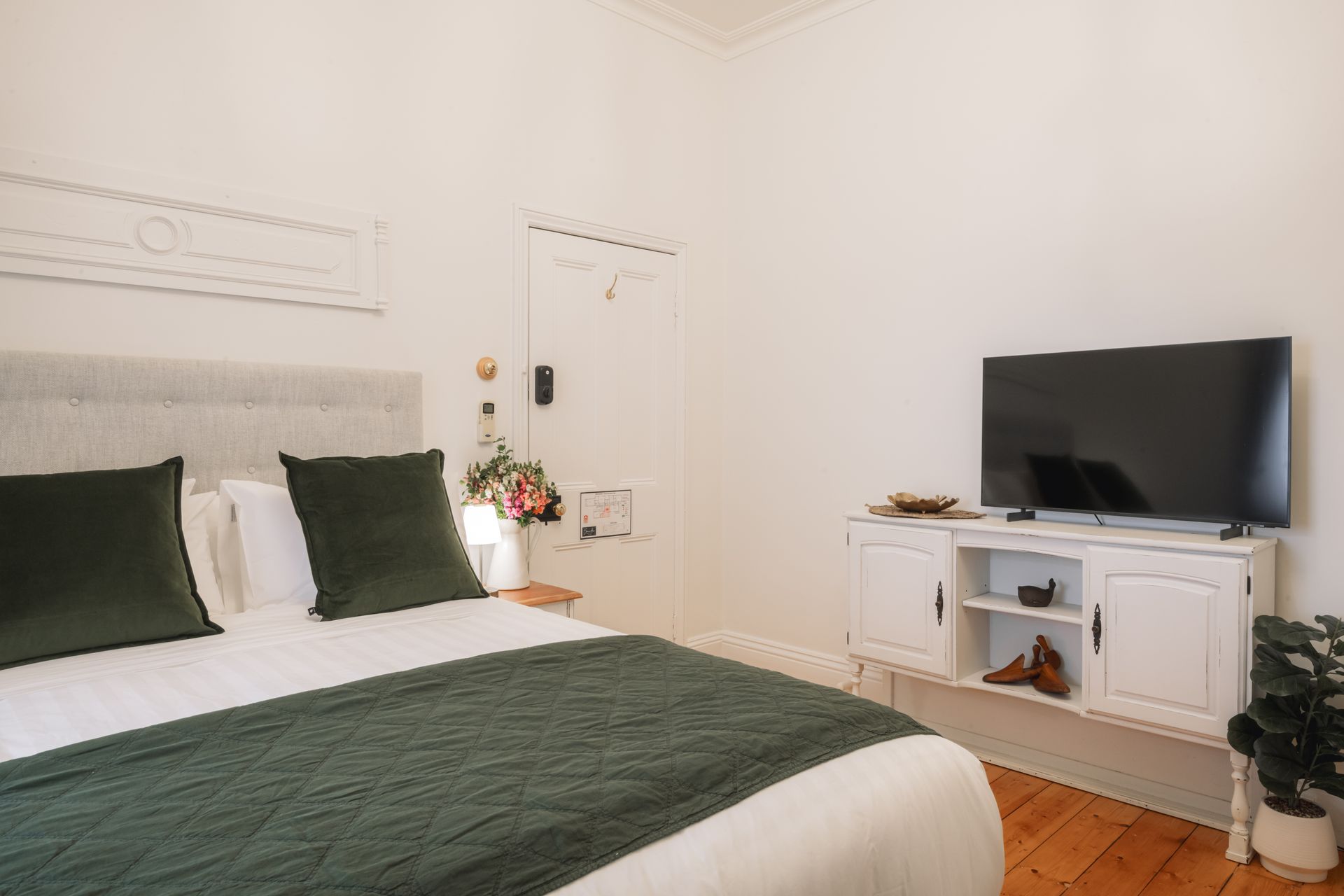 A bedroom with a king size bed and a flat screen tv.