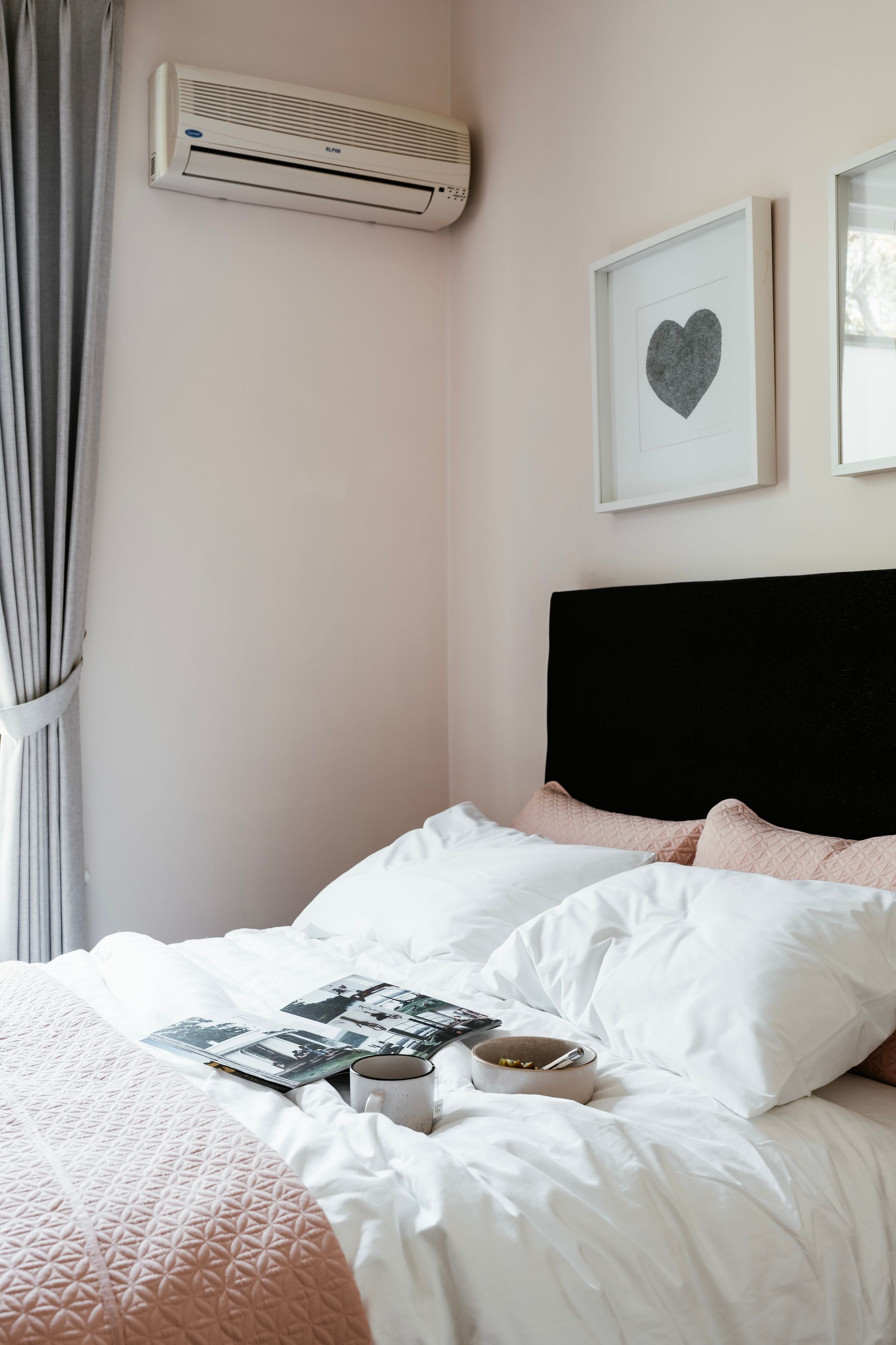 A bedroom with a bed and a nightstand with a vase of flowers on it.