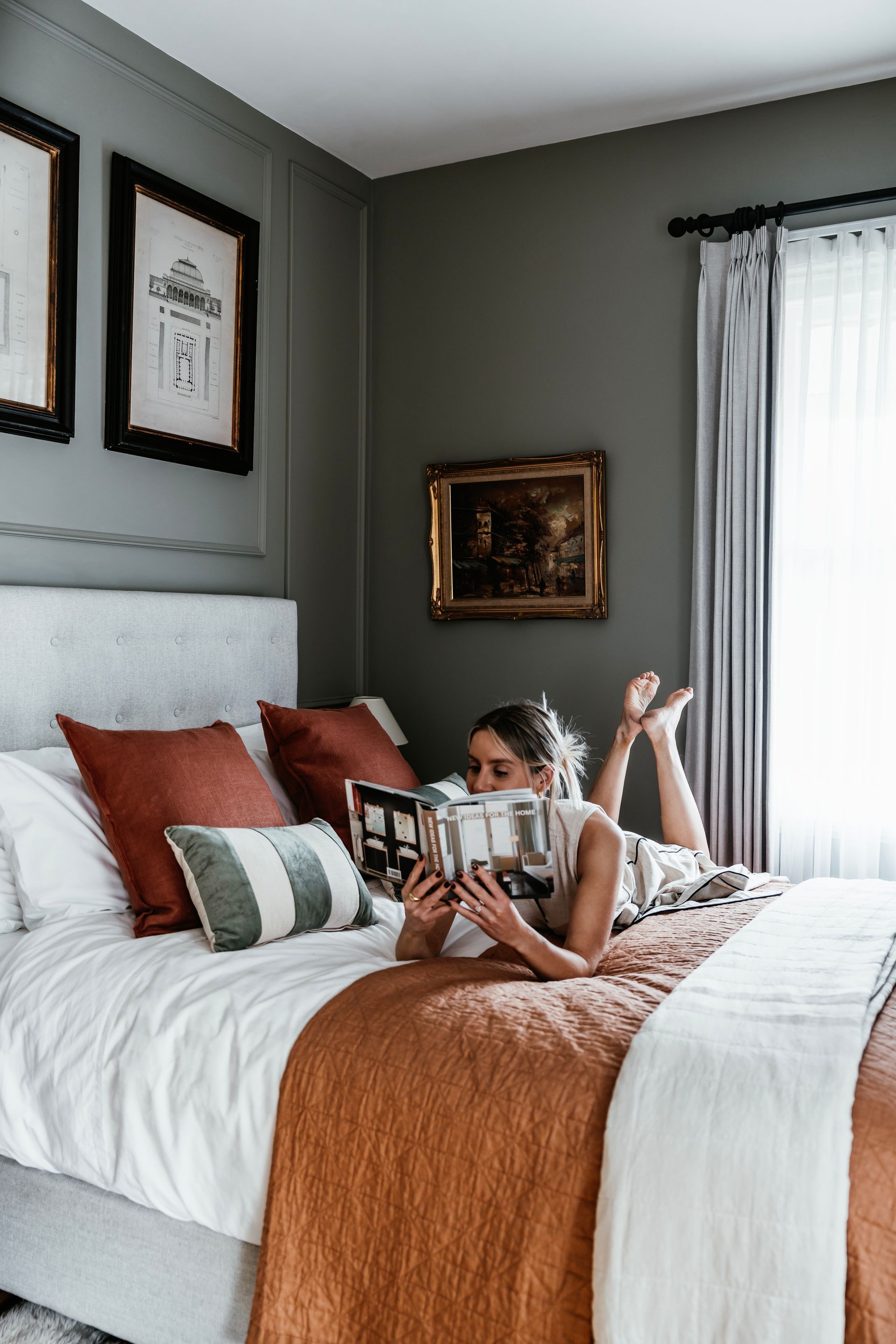 A bedroom with a bed and a nightstand with a vase of flowers on it.