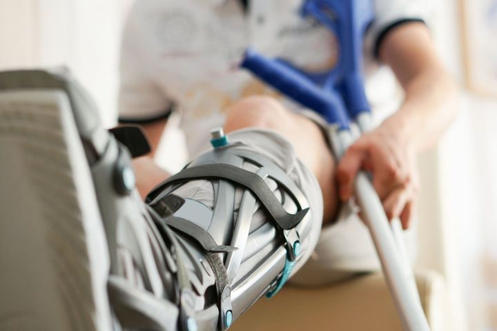 Eine Person mit einem Gipsbein benutzt eine Krücke.
