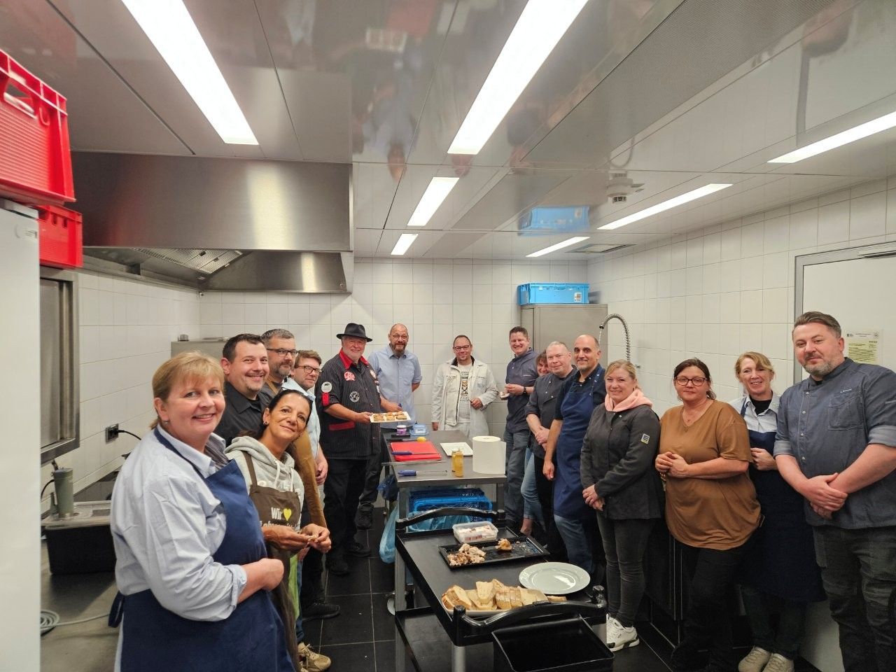 Eine Gruppe von Menschen in einer Küche, die in die Kamera lächeln.