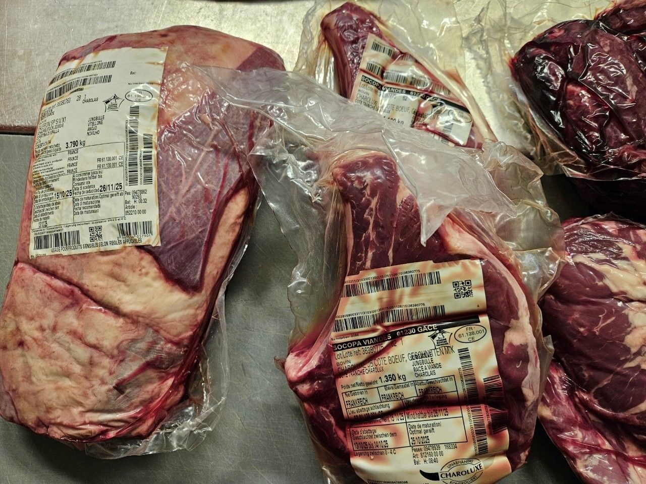 Rohe Rindfleischstücke in vakuumversiegelter Verpackung, mit Papieretiketten versehen.