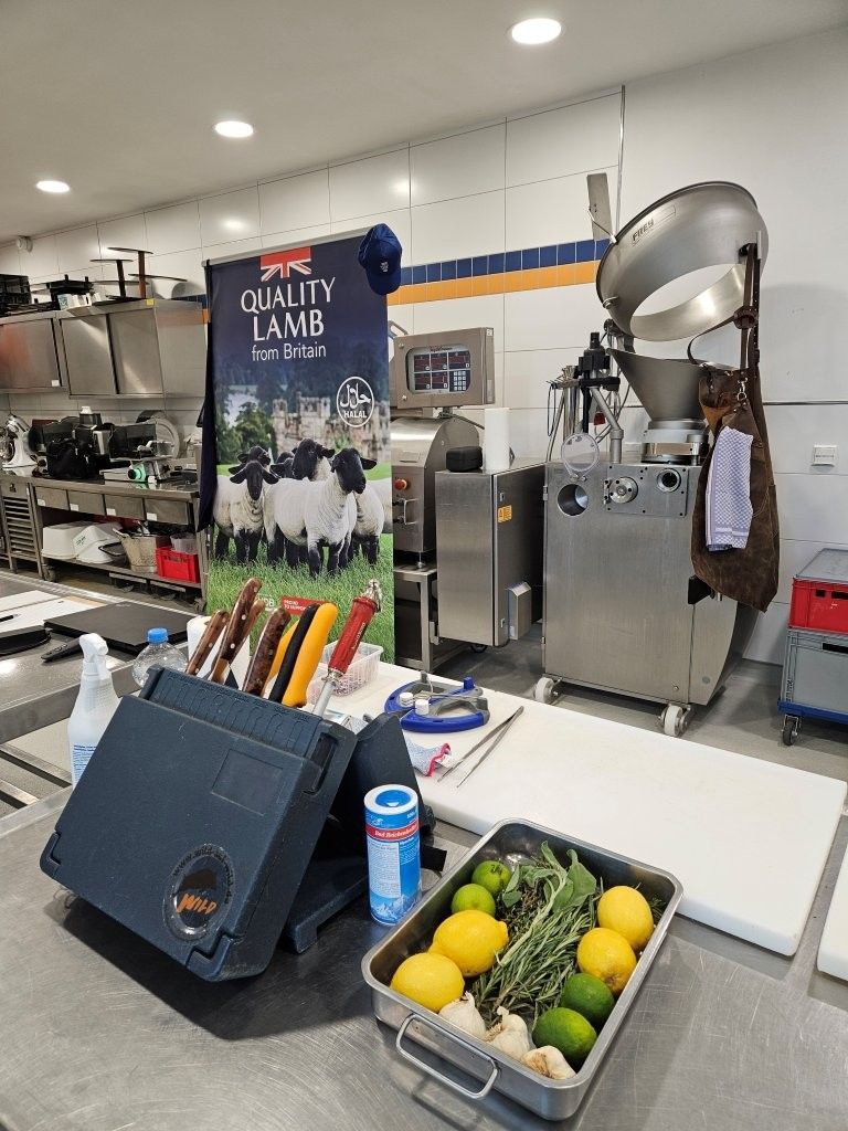 Eine Küchenszene mit Kochutensilien und Zutaten: Zitronen, Limetten und Kräuter auf einem Tablett.