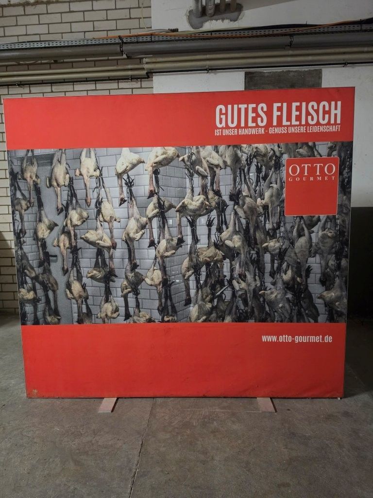 Red poster reading “GUTES FLEISCH” with hanging meat and a small red “OTTO” logo.
