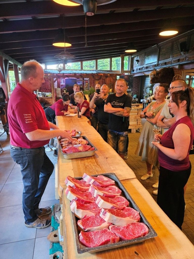 Menschen probieren Speisen an einem langen Buffet in einer Markthalle oder Lebensmittelhalle.