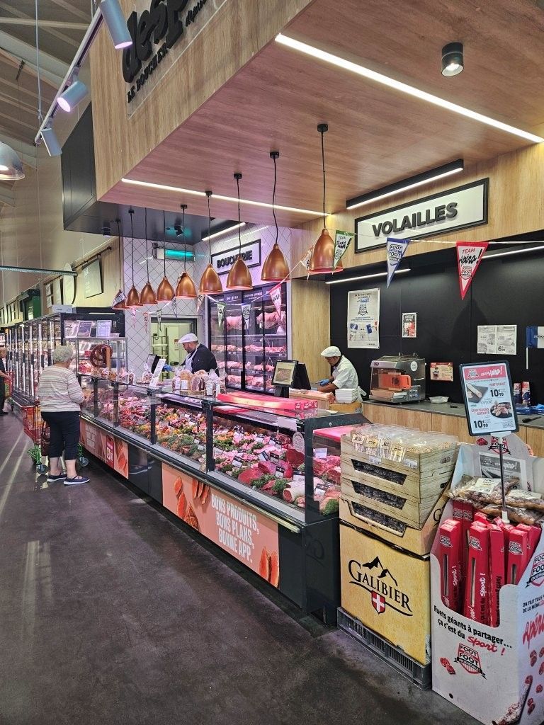 Käse- und Fleischtheke in einem Lebensmittelgeschäft mit Kühlvitrinen und einem „Viola's“-Schild unter einer holzgetäfelten Decke.