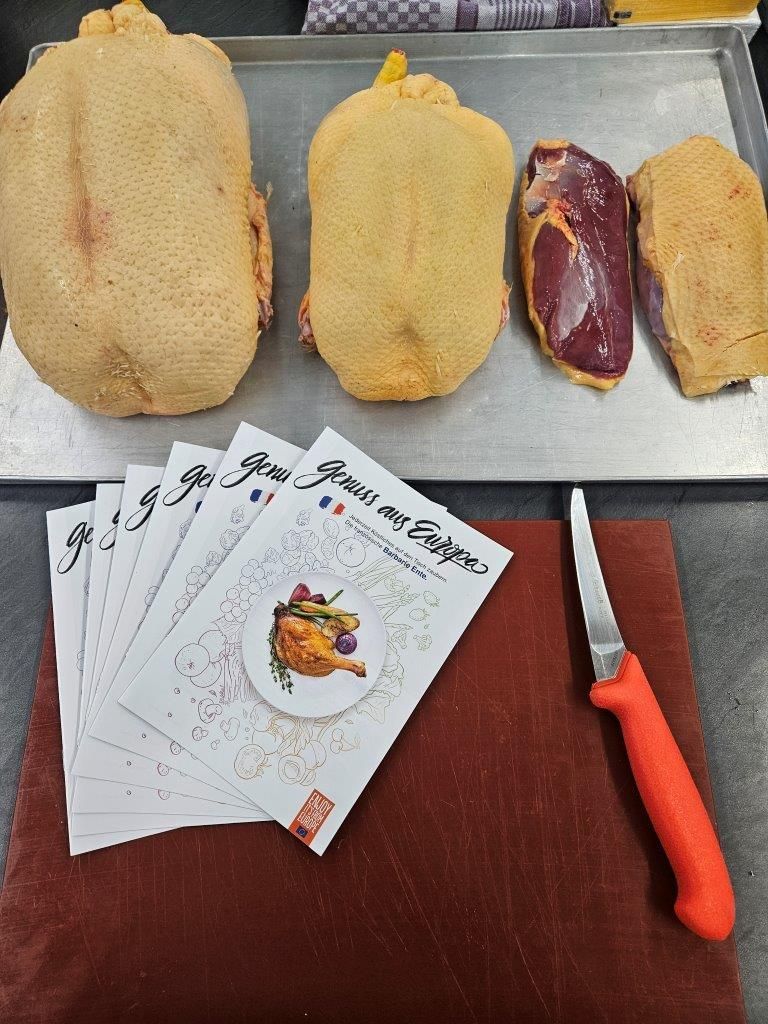 Fleisch auf Schneidebrett mit Flyer daneben und einem Messer