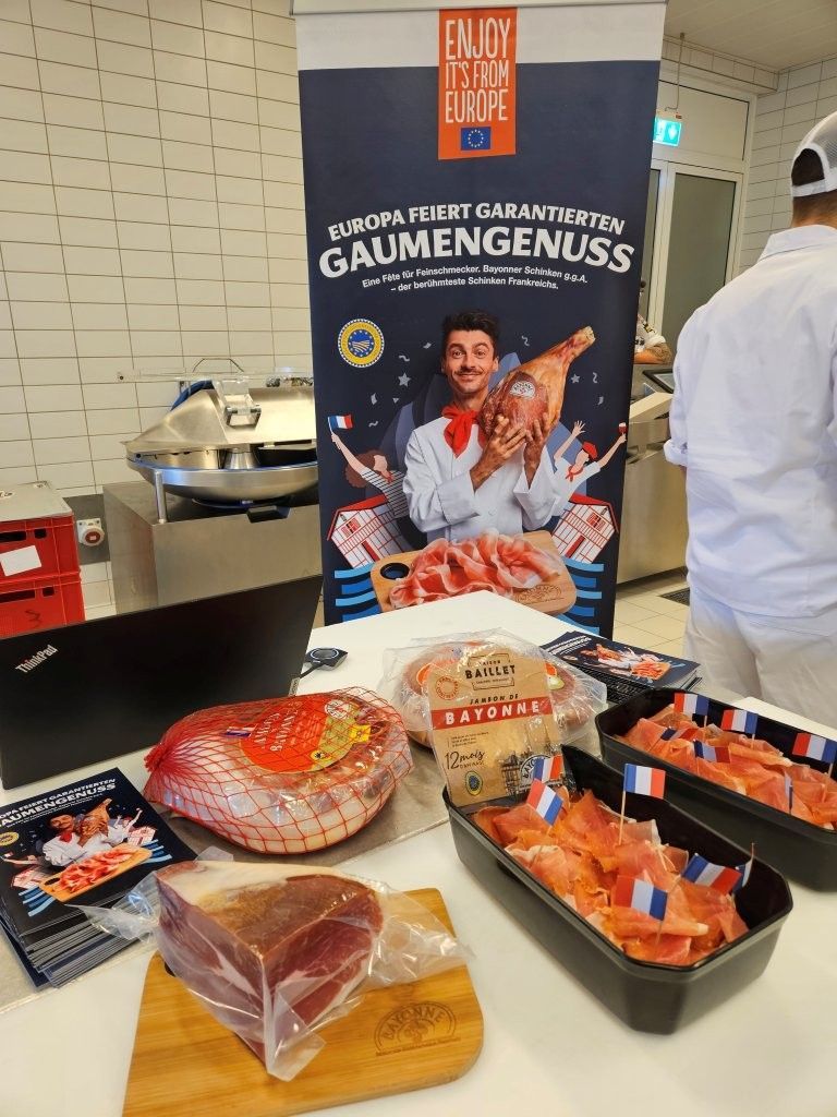 Mit Schinken dekorierter Tisch und Banner im Hintergrund