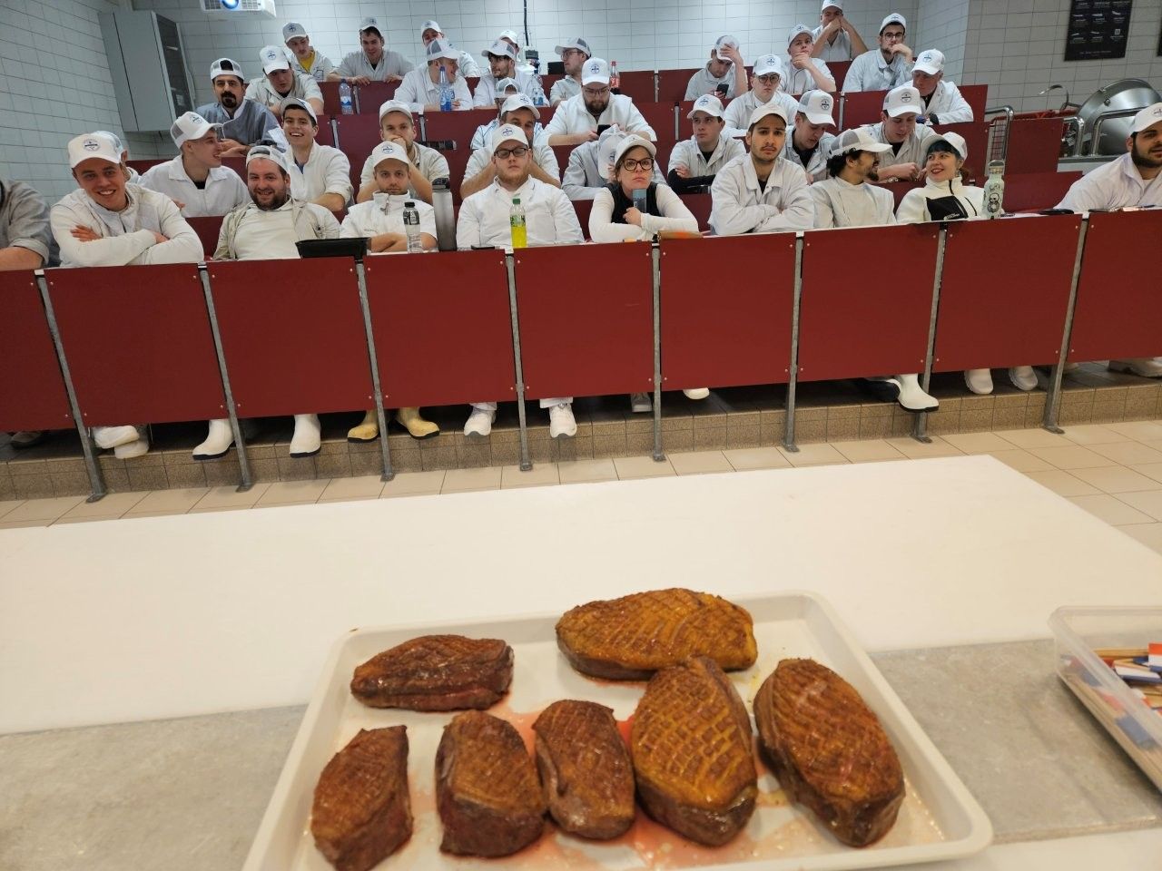 gebratene Entenbrüste mit Schulungsteilnehmern im Hintergrund