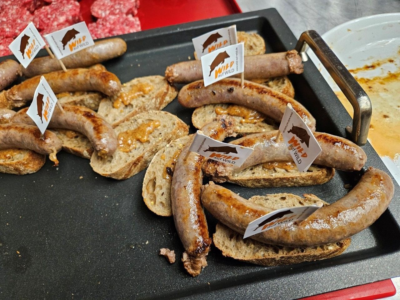 Bratwurst aus Wild mit Senf auf Baguette 