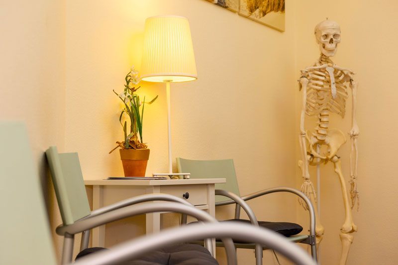Ein Arzt spricht mit einem Patienten und hält dabei ein Klemmbrett in der Hand.