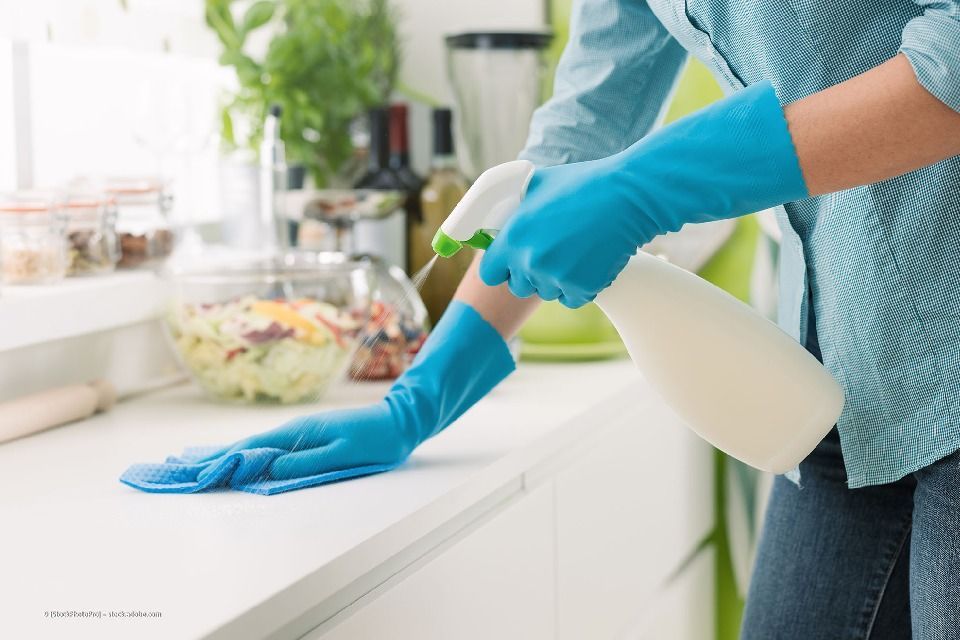 Frau reinigt Küchenoberfläche