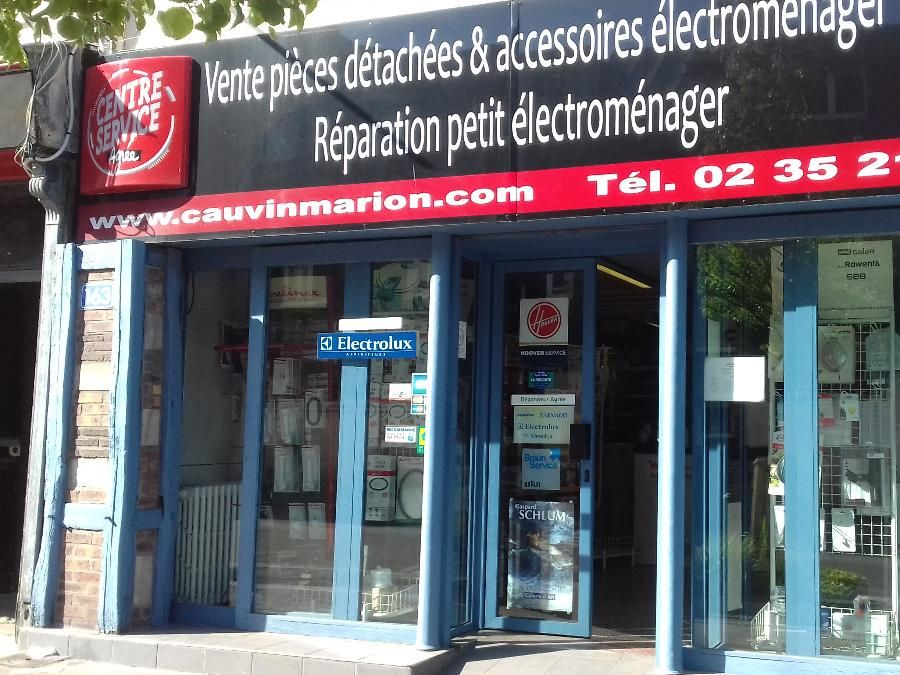 Façade : centre dépannage avec enseigne pour pièces, accessoires et réparations d’électroménagers. Cadre bleu, site web et numéro de téléphone visibles.