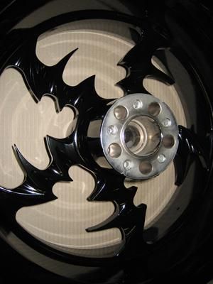 Eine Nahaufnahme eines Motorradrads mit einem Fledermaus-Design darauf