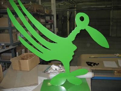 Eine grüne Vogelstatue steht auf einem Tisch in einem Lagerhaus.