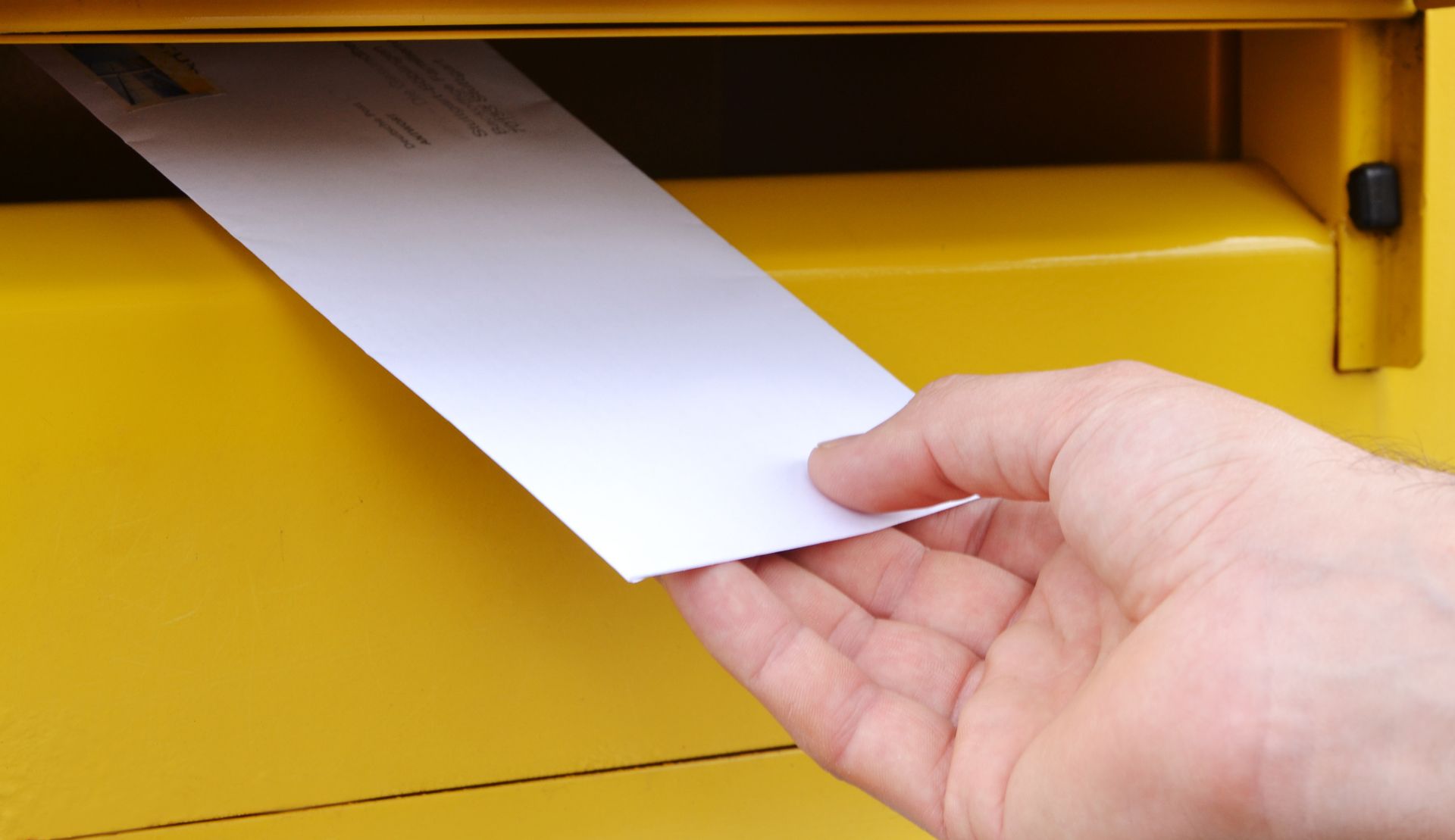 Une personne en train de poster une lettre