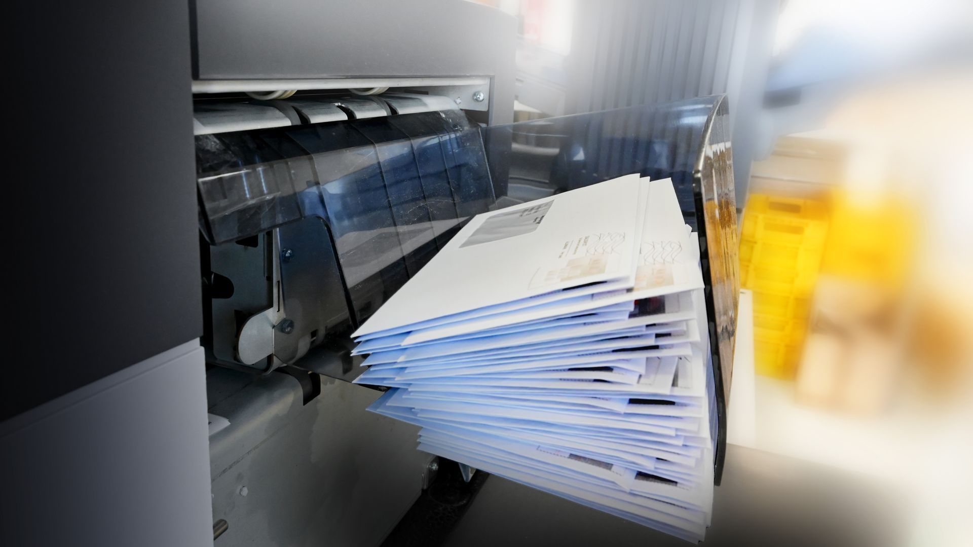 Une pile d'enveloppes sortant d'une machine de mise sous pli industrielle