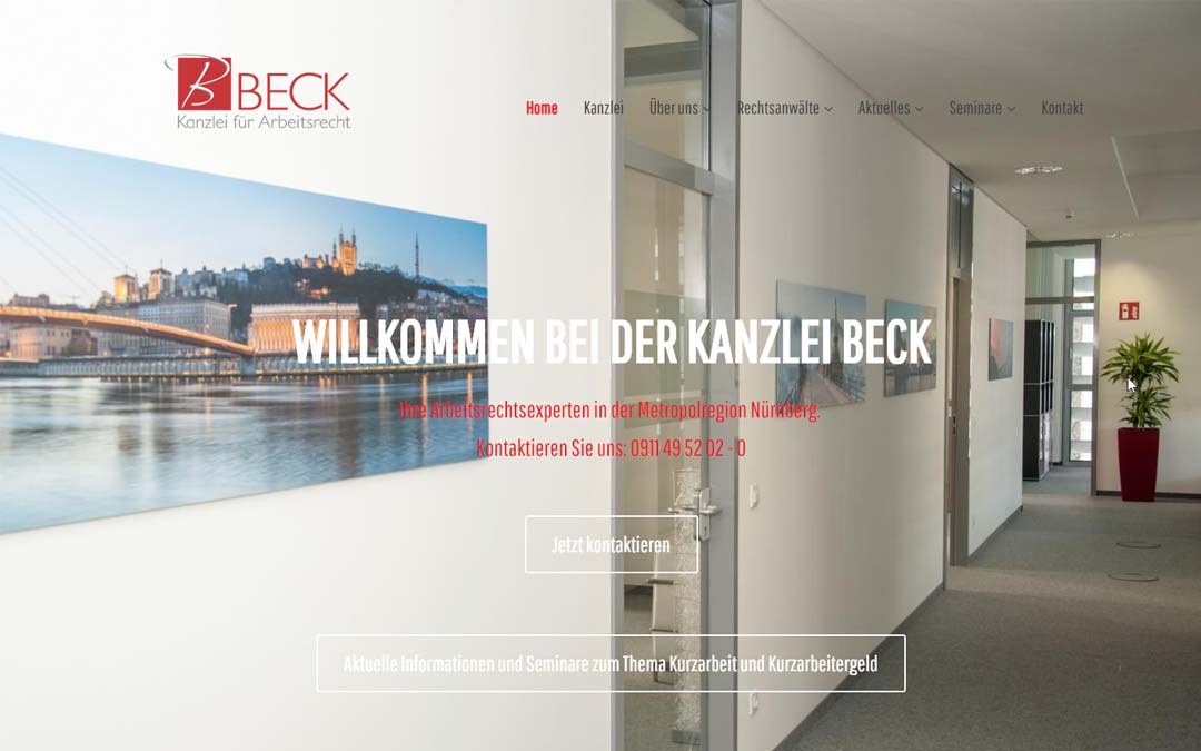 Büroinnenraum mit einer weißen Wand mit Logo und Text, die zu einem Korridor führt.