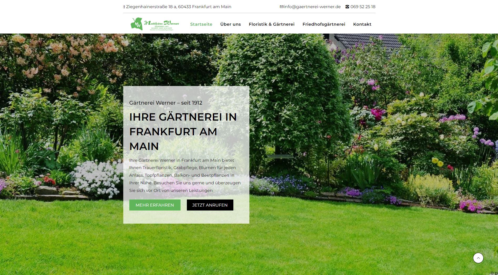 Grüner Rasen, bunte Pflanzen und die Willkommensbotschaft einer Gartenbauschule in Frankfurt am Main.