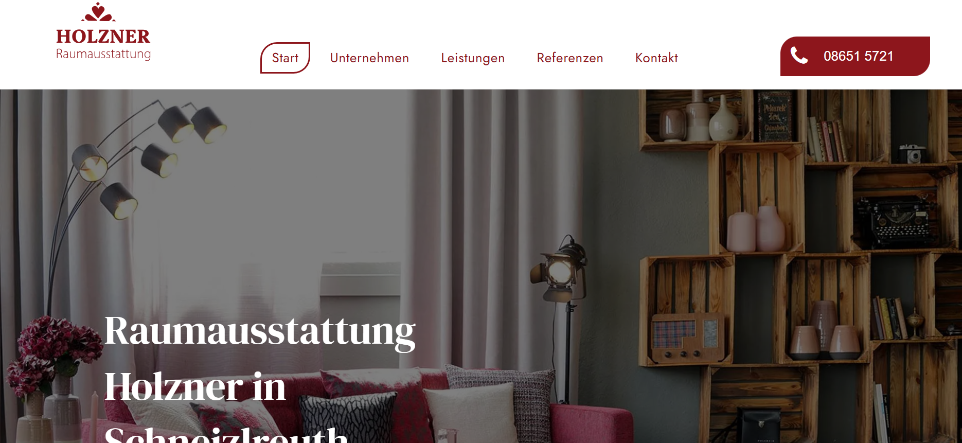 Website homepage hero for Holzner Raumgestaltung with cozy interior decor and shelving display