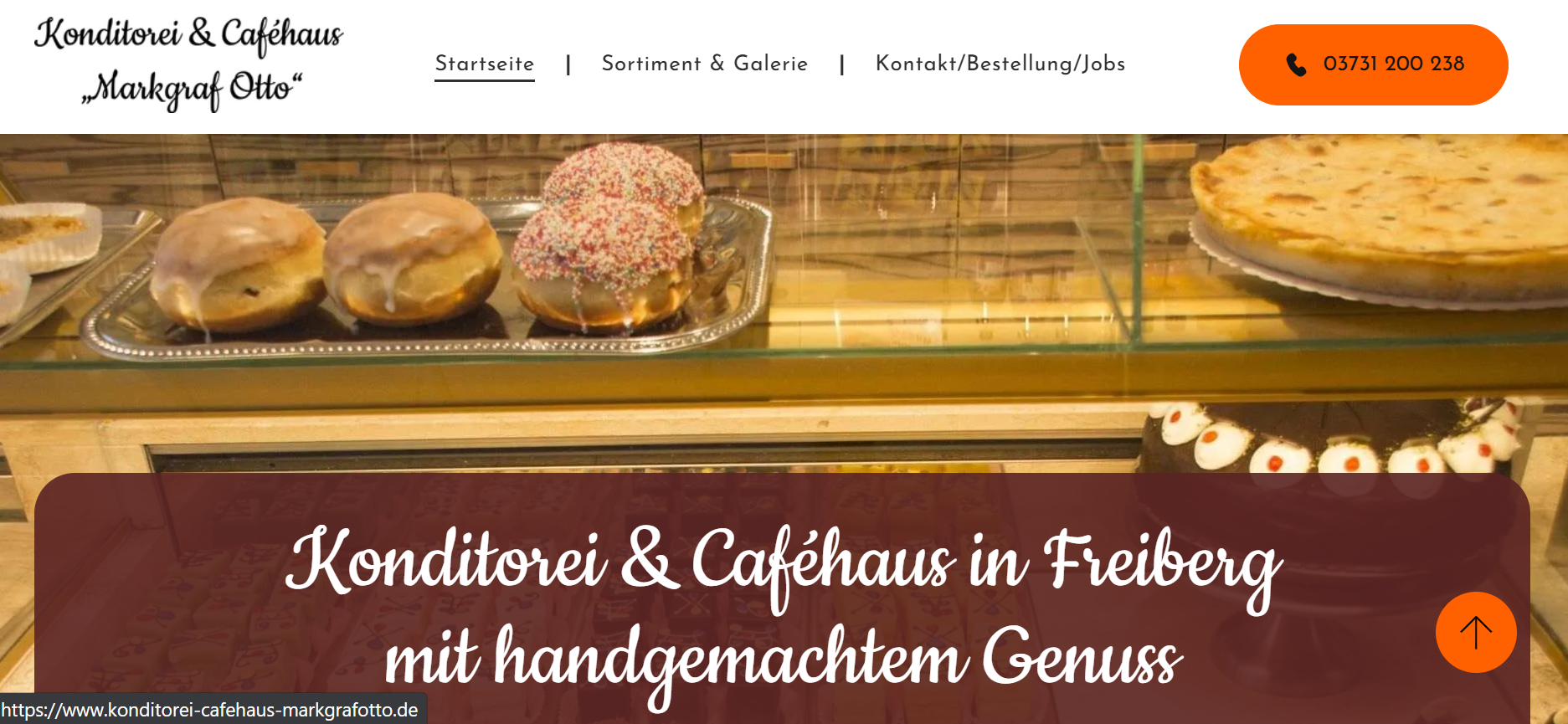 Bakery storefront with pastries and banner reading “Konditorei & Caféhaus in Freiburg mit handgemachtem Genuss”