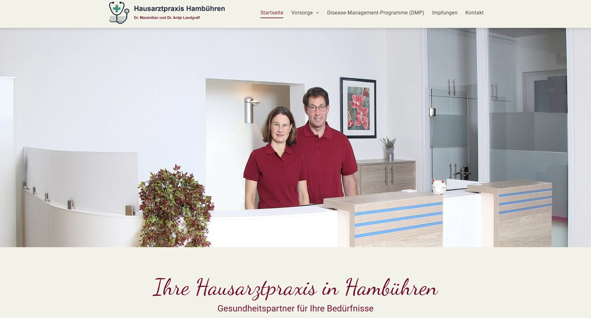 Zwei Menschen in roten Hemden stehen in einer Hamburger Praxis an einem Empfangstresen.