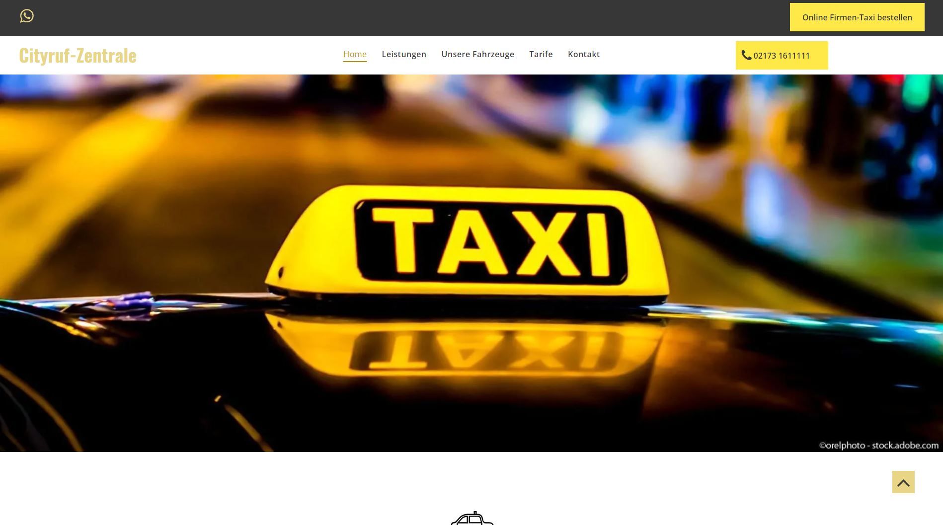 Gelbes Taxidachlicht vor einer verschwommenen Stadtstraße bei Nacht.