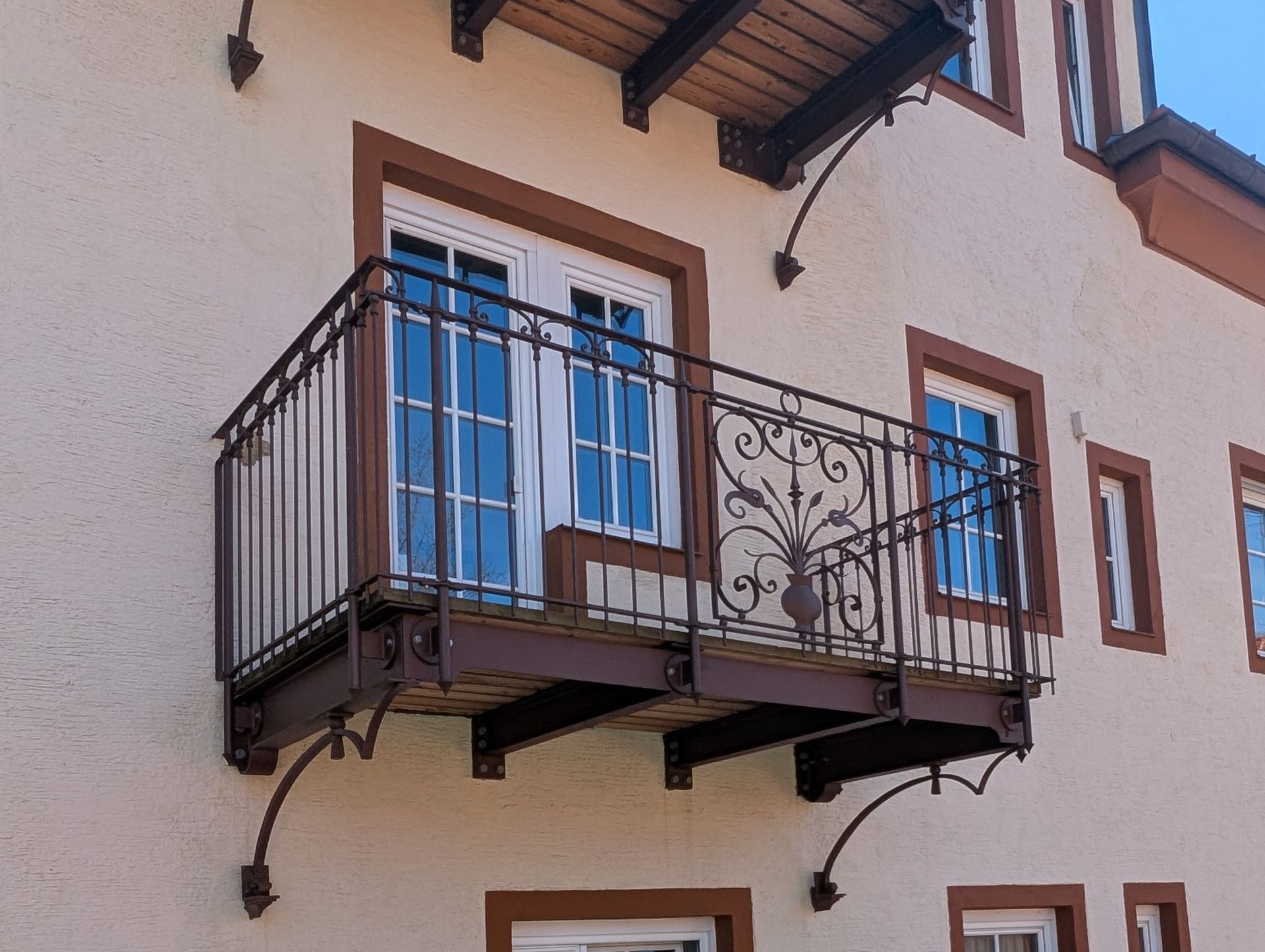 Balkon mit verziertem Schmiedeeisen-Geländer an Hausfassade