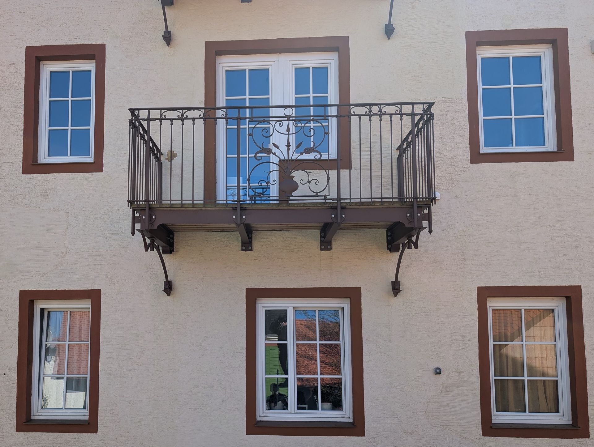 Traditioneller Balkon mit verziertem Schmiedeeisen-Geländer an Fassade