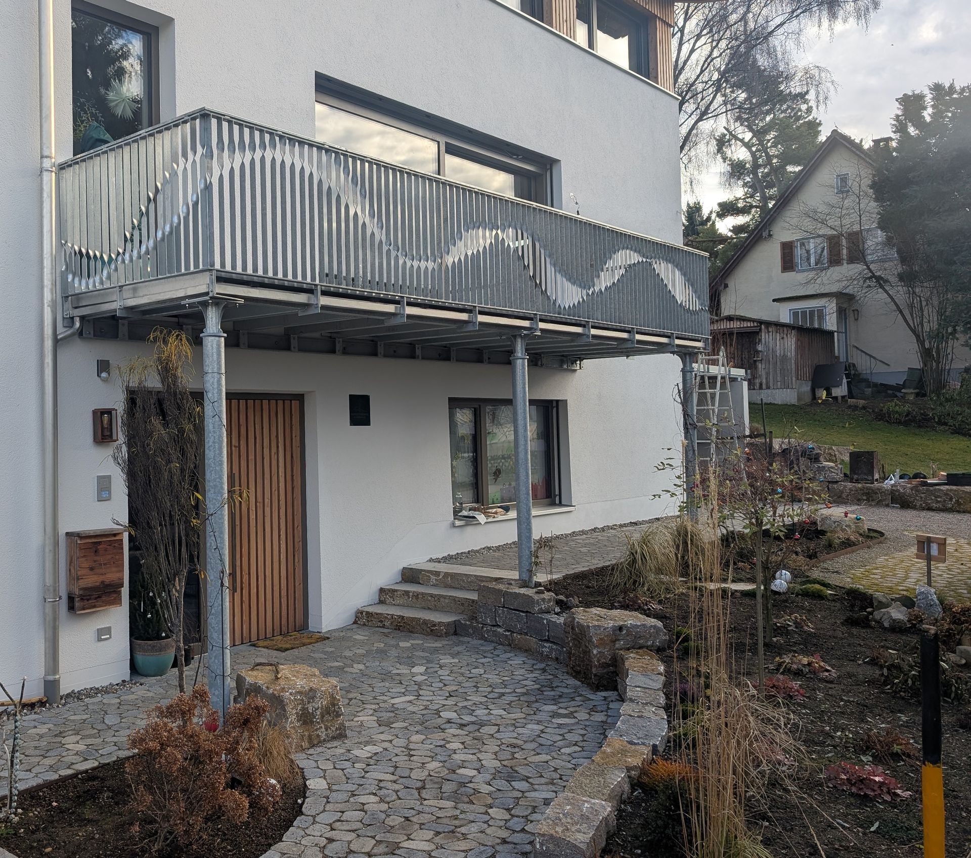 Hausfassade mit Balkon und geschwungenem Metallgeländer im Außenbereich