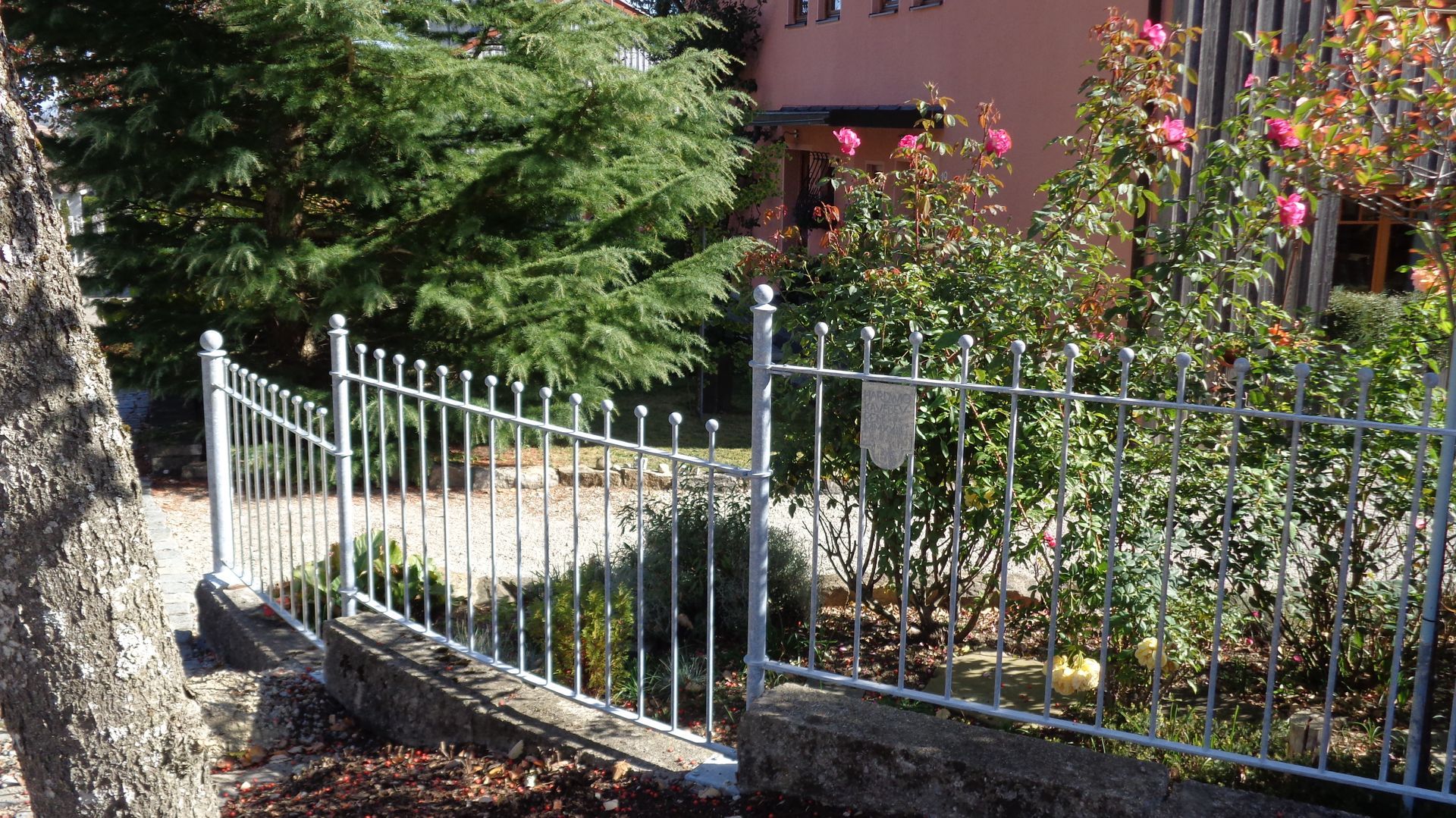 Niedriger Metallzaun mit Kugelspitzen im Garten